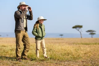 Famiglia composta da padre e figlio in vacanza in un safari africano che si gode la vista della savana Famiglia composta da padre e figlio in vacanza in un safari africano che si gode la vista della savana