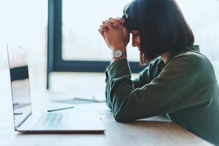 Vista laterale di una donna d'affari esausta in cerca di una soluzione usando un computer portatile Vista laterale di una donna d'affari esausta in cerca di una soluzione usando un computer portatile